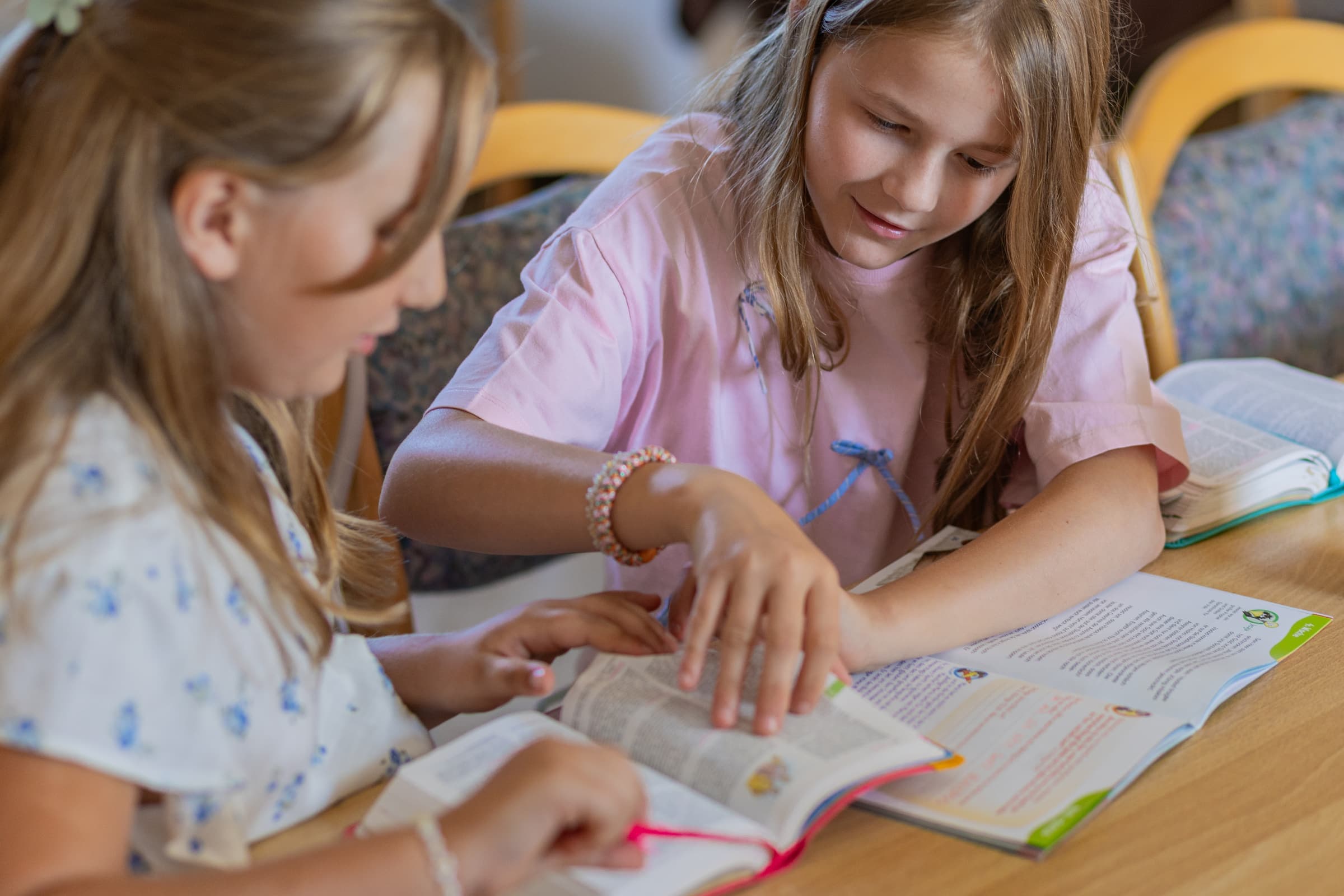 Zwei Mädchen schlagen zusammen eine Stelle in der Bibel nach