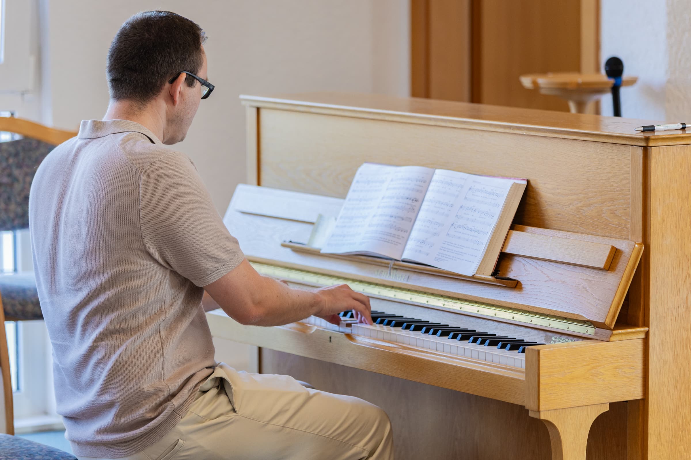 Ein Mann begleitet den Gesang am Klavier
